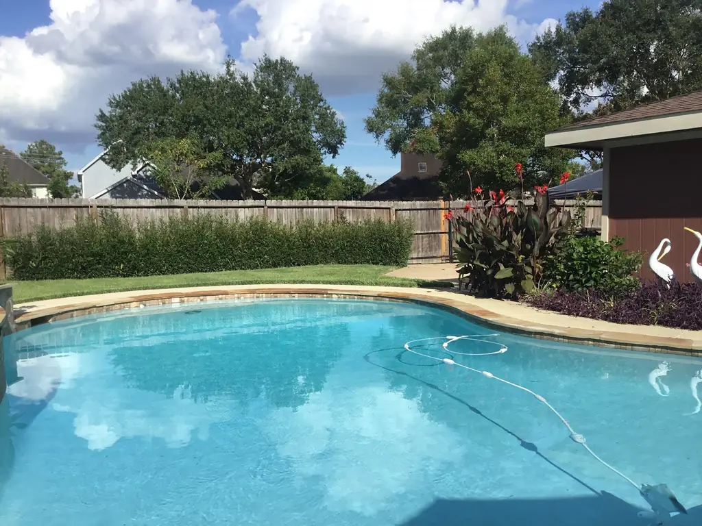 A Fort Bend County backyard pool with the automatic cleaner hose in the water